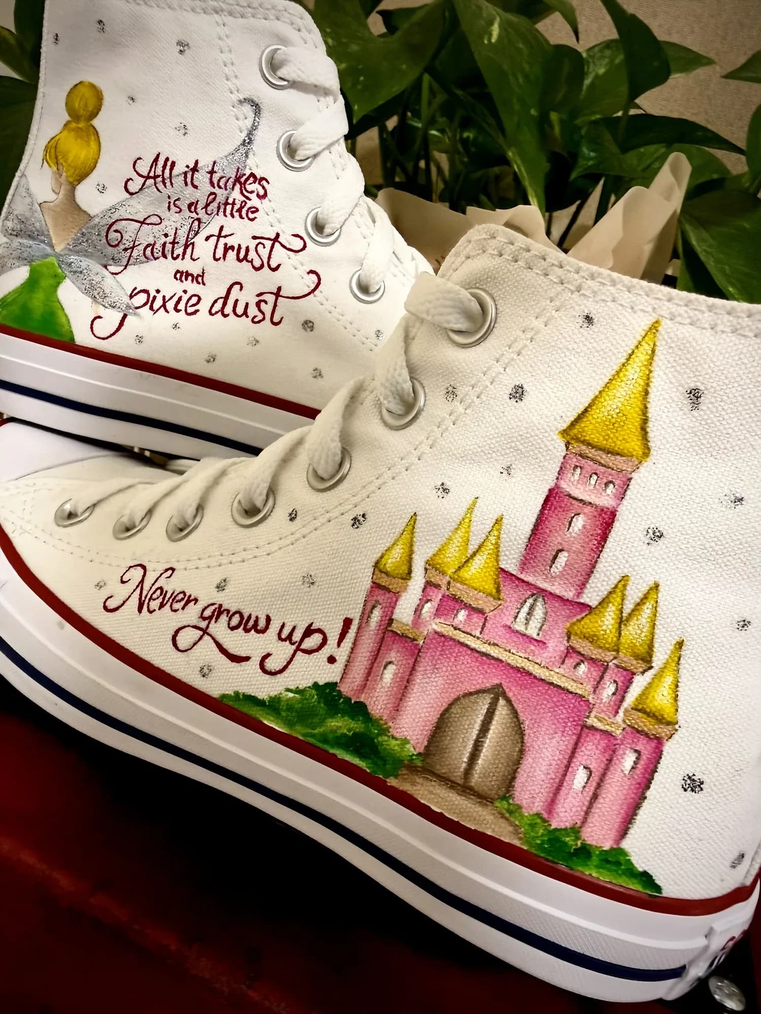 White high-top hand-painted with a pink castle and 'Never grow up'