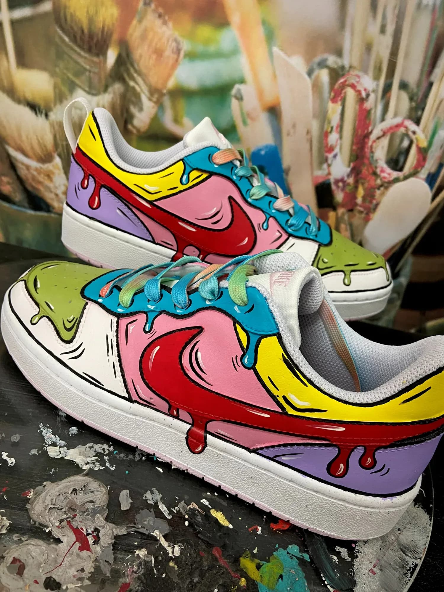 White sneakers hand-painted in a pop-art style with colourful paint drips