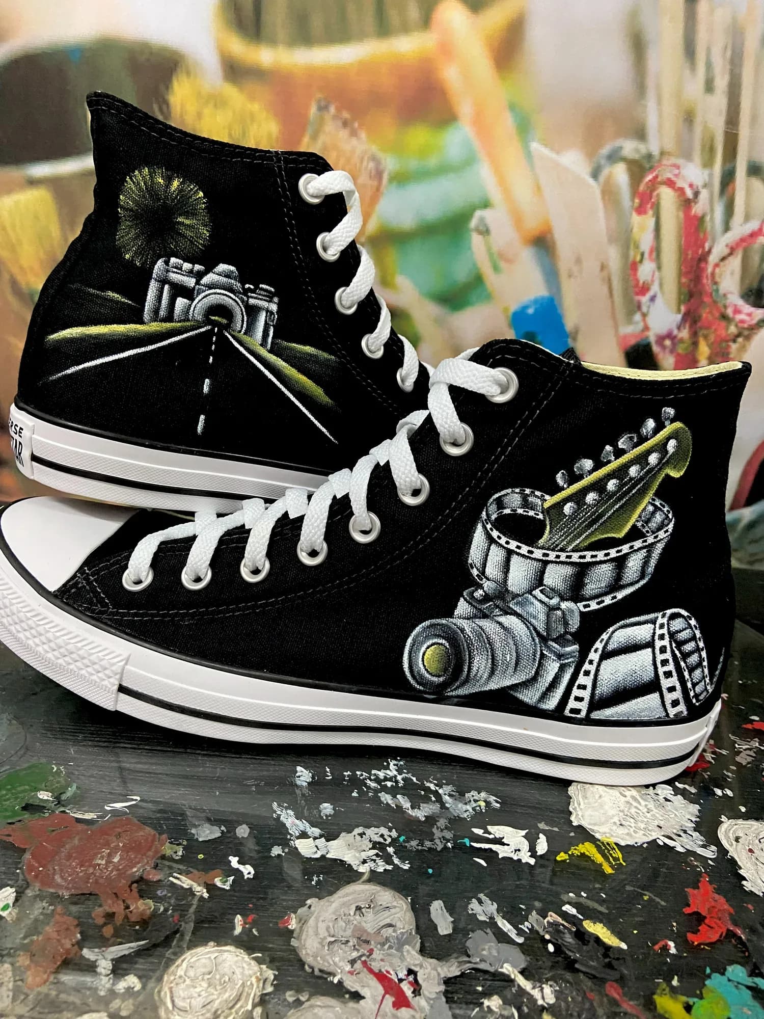 Black high-tops hand-painted with a camera and a road
