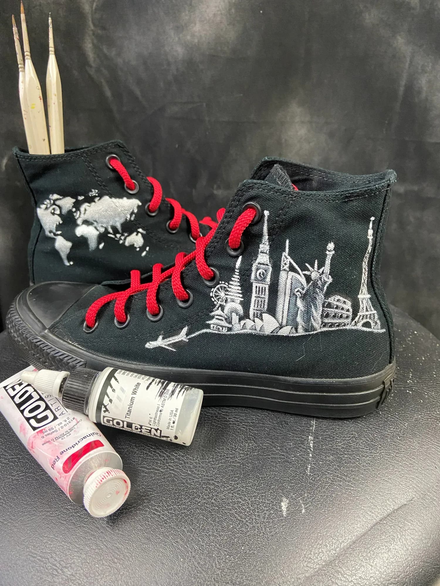 Black high-tops hand-painted with world landmarks and red laces