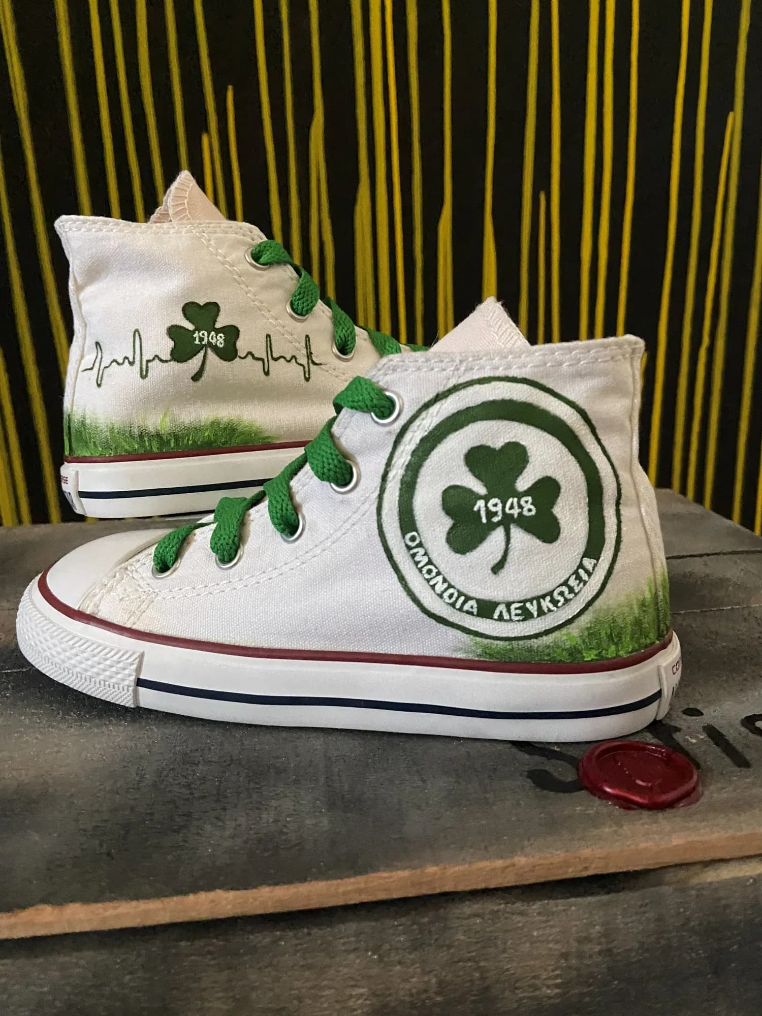 White high-top with green laces and a large hand-painted Omonia badge