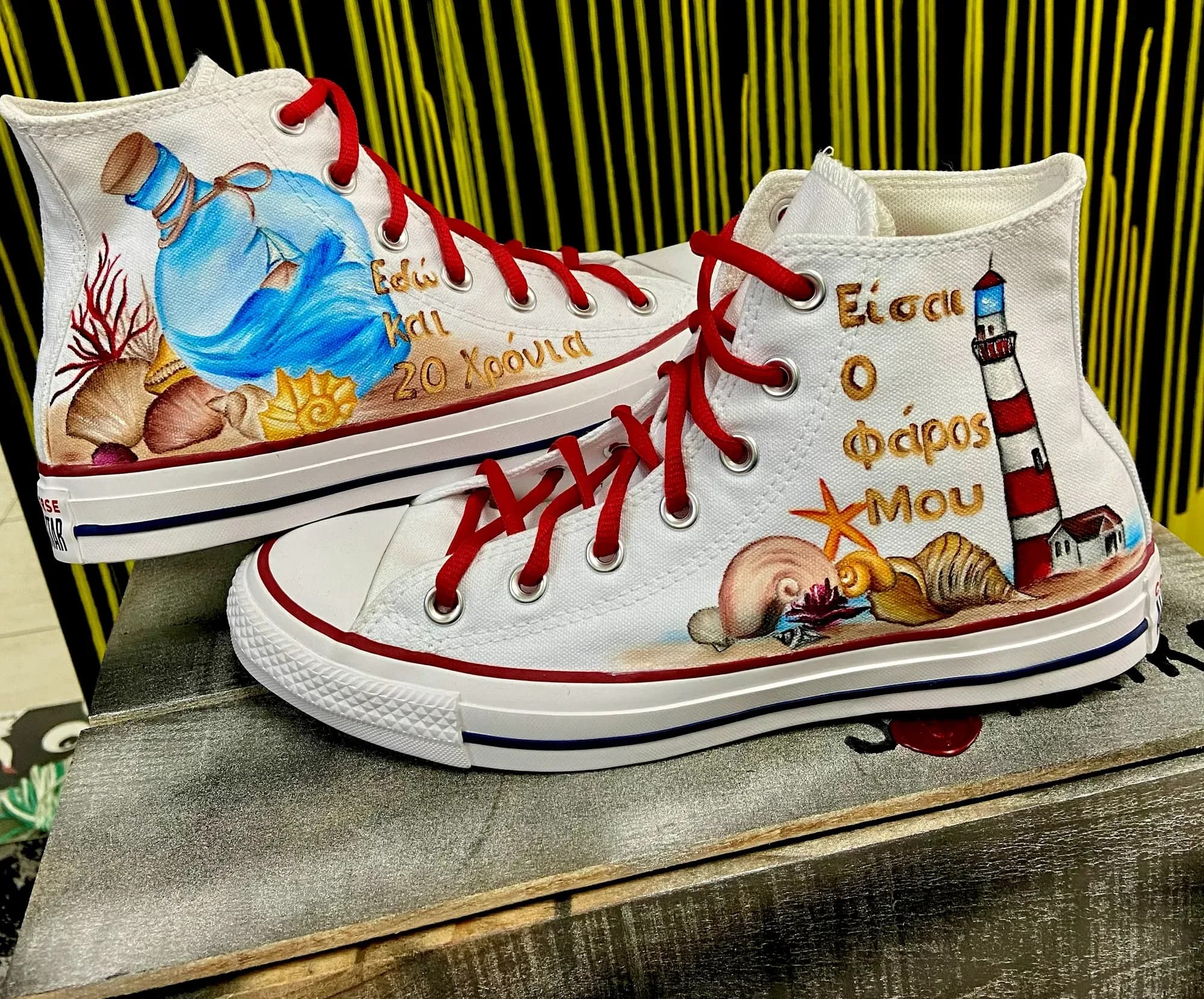 White high-tops hand-painted with a lighthouse, a bottle and red laces