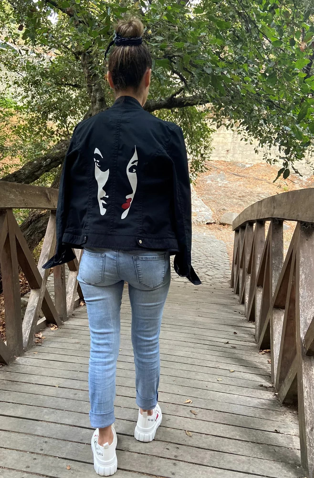 Black denim jacket hand-painted with a woman's face on the back