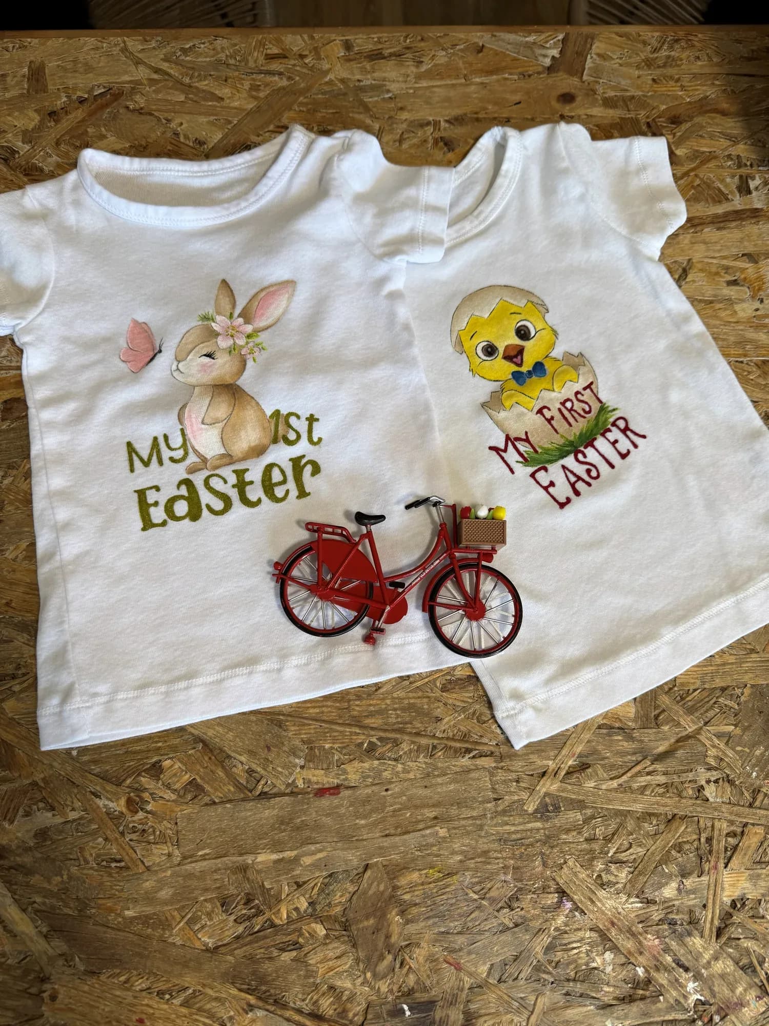 White kids' T-shirts hand-painted with an Easter bunny and chick