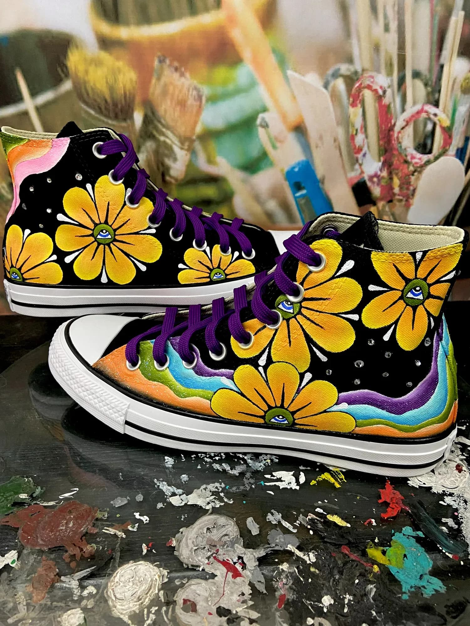 Black high-tops with yellow flowers and a rainbow painted on the sole