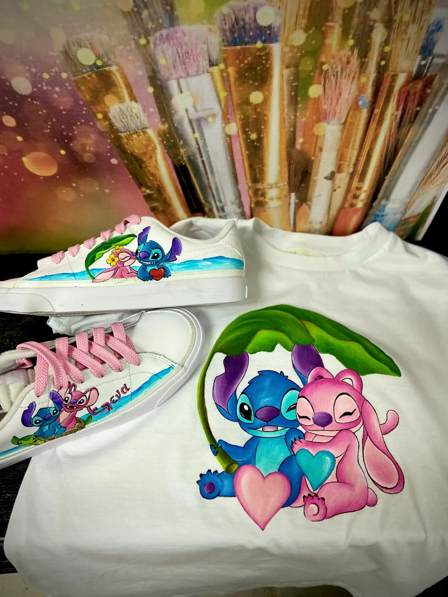 Painted T-shirt and sneakers with Stitch and Angel among brushes in the studio