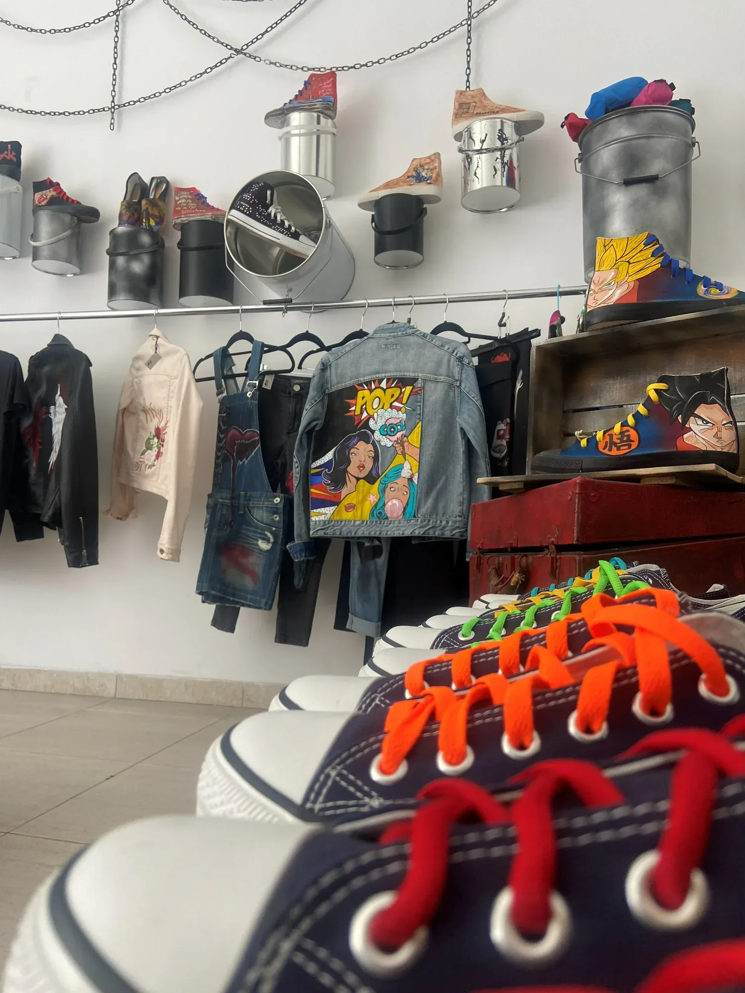 The studio wall with painted jackets, shoes and bucket planters