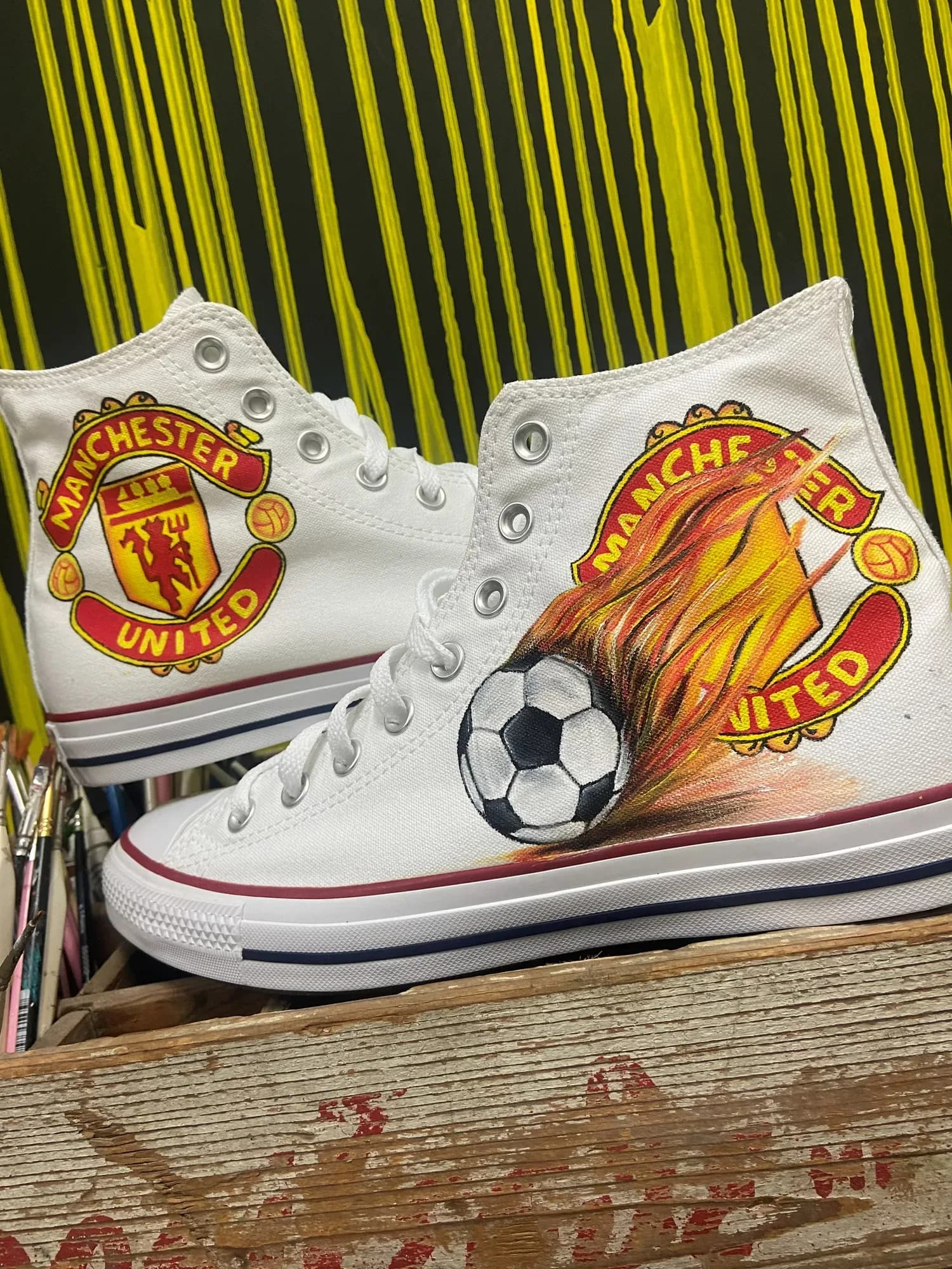 White high-tops hand-painted with the Manchester United badge and a flaming football